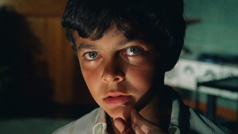 A young boy looks directly into the camera in Don't Torture a Duckling