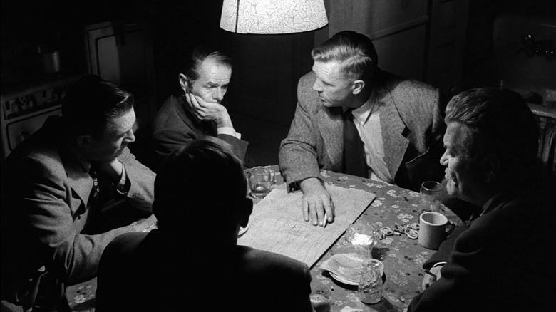 Men around a table make covert plans