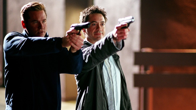 Val Kilmer and Robert Downey Jr pointing guns