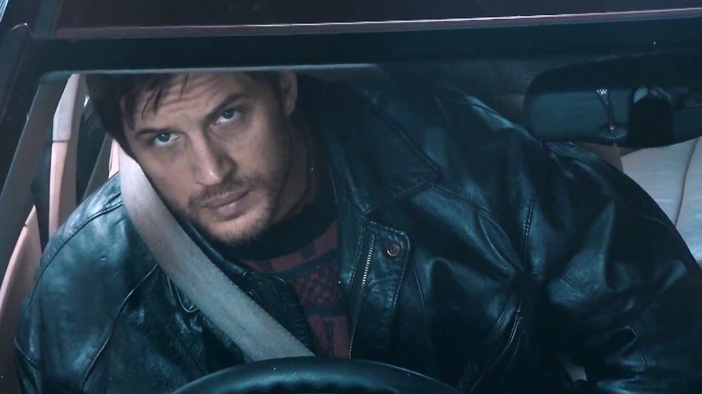 Tom Hardy peers up from behind the wheel 