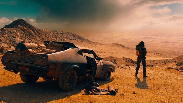 Mad Max stands by his car