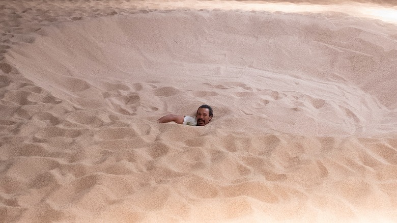 Cristobal drowning in sand