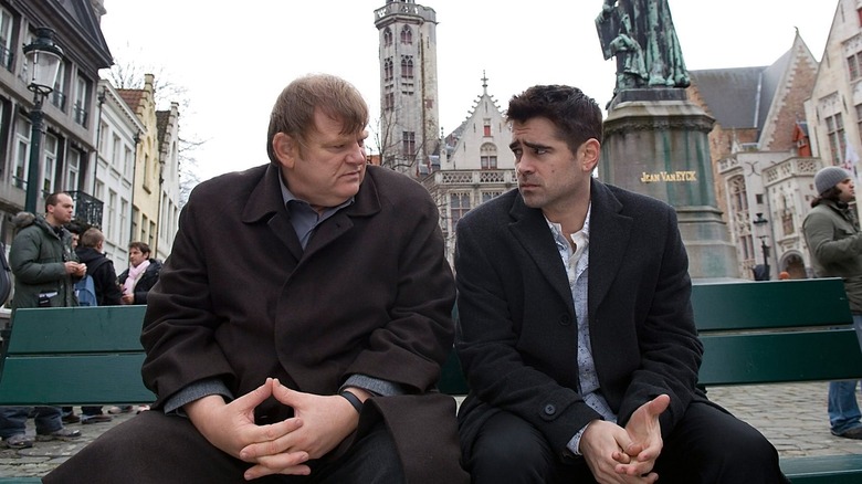 Brendan Gleeson and Colin Farrell as Ken and Ray sitting on a bench outdoors in the film In Bruges