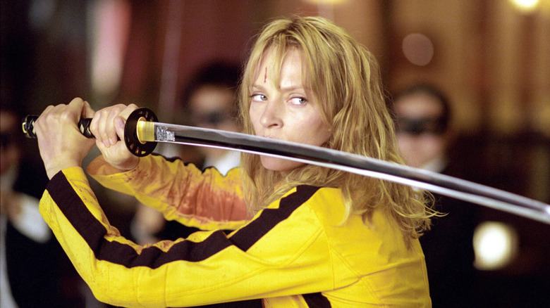 Uma Thurman as The Bride, wielding a katana surrounded by fighters in Kill Bill Volume 1