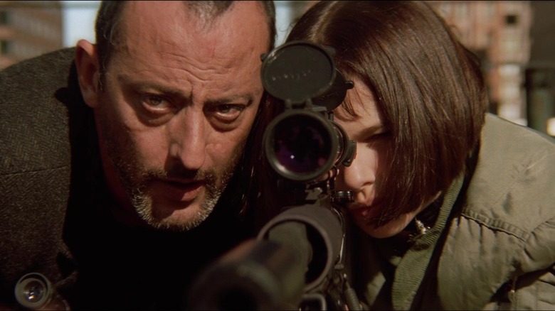 Jean Reno and Natalie Portman as Léon and Mathilda, looking down the sights of a sniper rifle together in Léon: The Professional