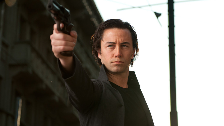 Joseph Gordon-Levitt as Joe, aiming a gun in Looper