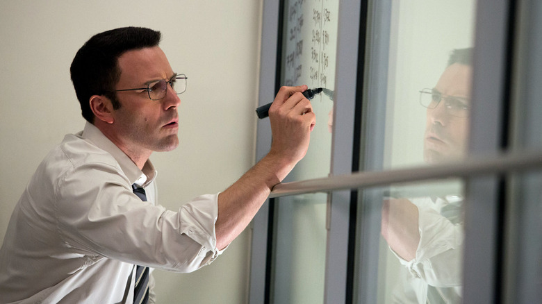 Ben Affleck as Christian Wolff, writing on a glass wall in The Accountant