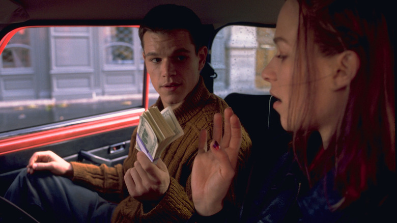 Matt Damon as Jason Bourne offering money to Franka Potente as Marie in The Bourne Identity