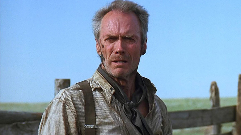 Clint Eastwood as Will Munny, standing near a fence in Unforgiven