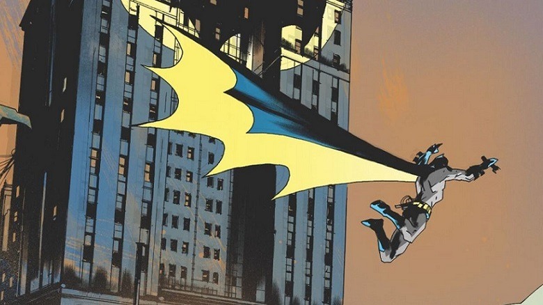 Batman swings through the skyline of Gotham, a huge billowing cape behind him