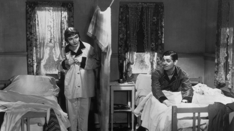 Ellie (Claudette Colbert) and Peter (Clark Gable) on opposite sides of a curtain in It Happened One Night