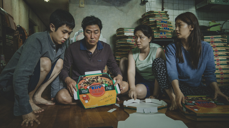 The Kim family making pizza boxes in Parasite