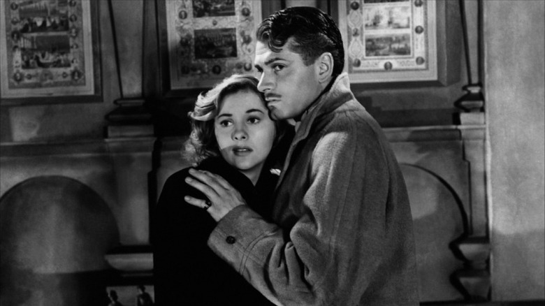 Mrs. de Winter (Joan Fontaine) clings to her husband (Laurence Olivier) in Rebecca