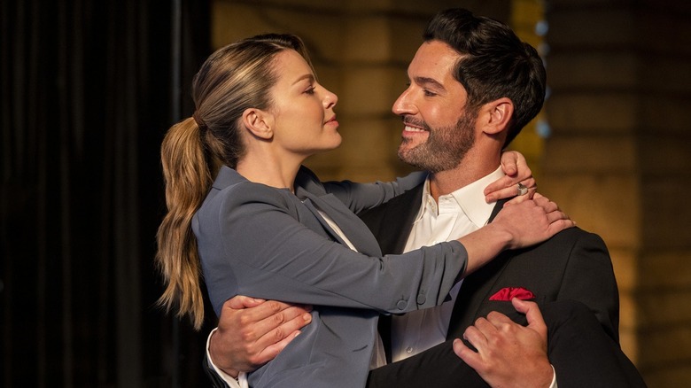 Tom Ellis' Lucifer Morningstar holding Lauren German's Chloe Decker in Lucifer