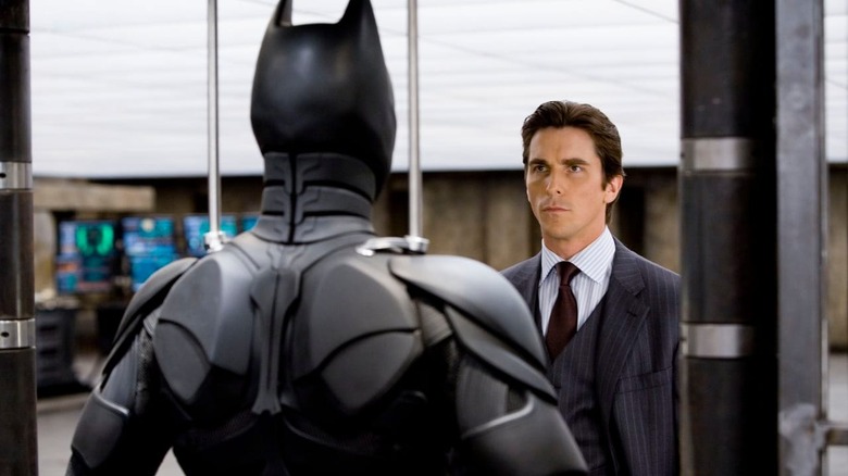 Bruce Wayne stares at Batsuit