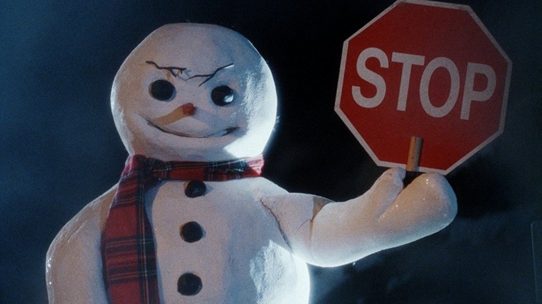 An evil snowman holds a stop sign