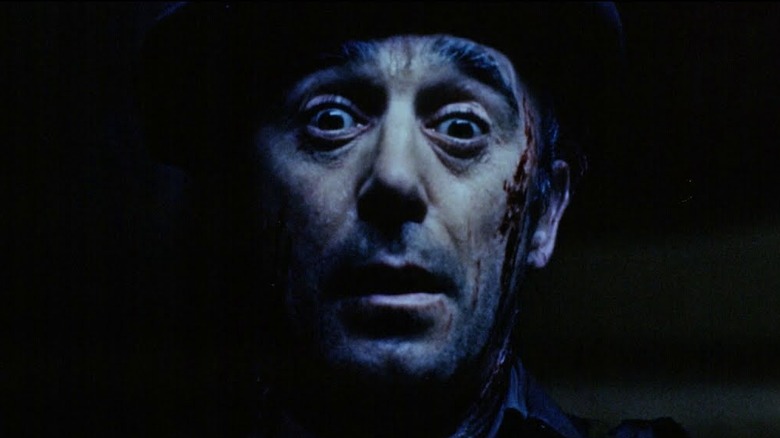 Close-up of a man looking frightened in the dark