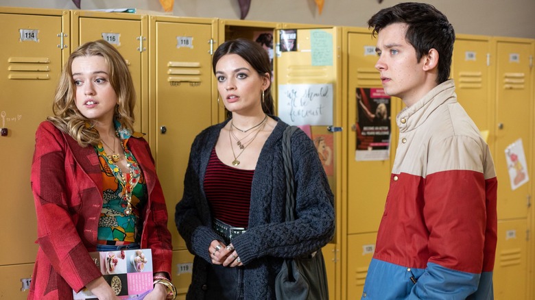 Asa Butterfield, Emma Mackey, and Aimee Lou Wood stand by lockers in "Sex Education"