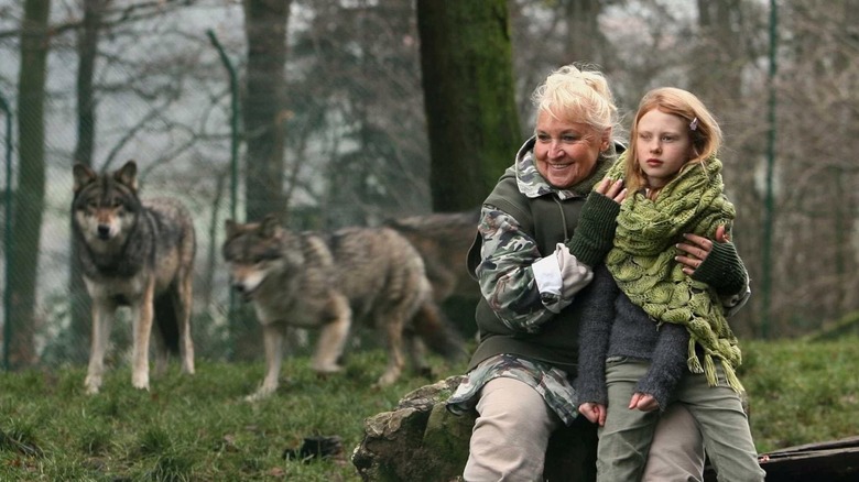 Misha sits on log with wolves