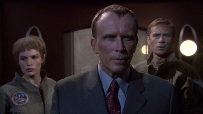 T'Pol (Jolene Blalock) and Trip (Connor Trinneer) stand behind Paxton (Peter Weller) in Star Trek: Enterprise