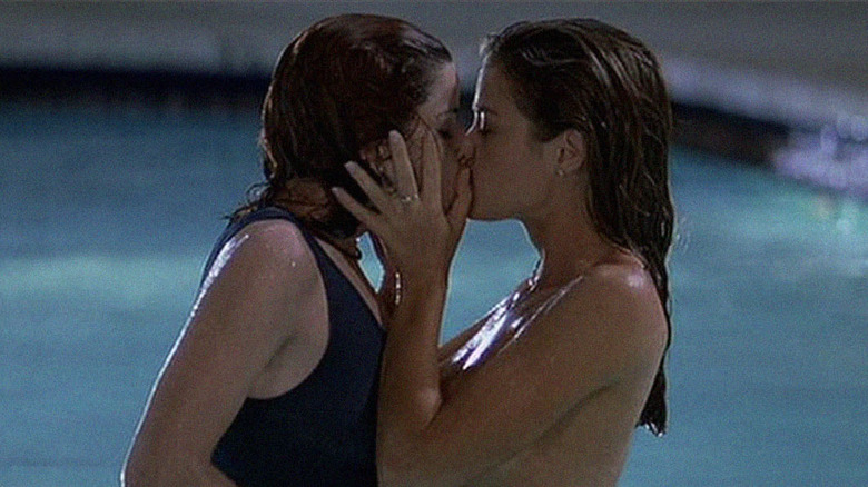 Two teenage girls kiss in a pool