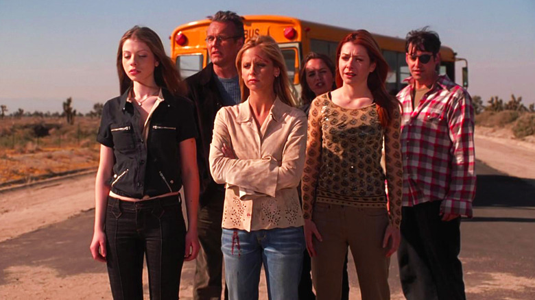 Sarah Michelle Gellar as Buffy, standing with her friends next to a school bus in Buffy the Vampire Slayer