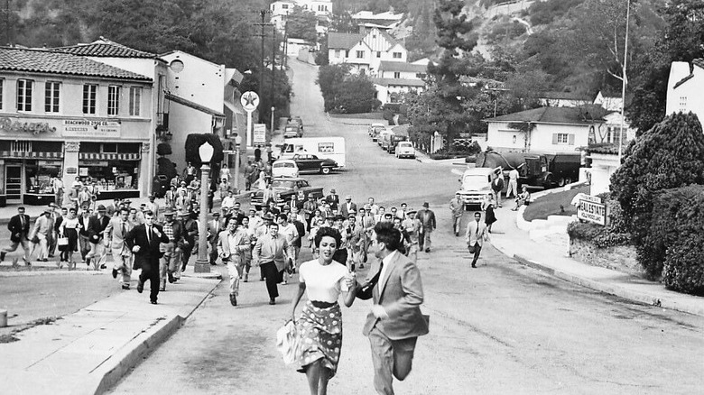 Man and woman running from town