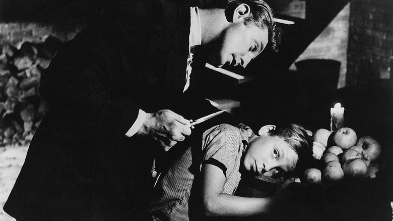 Mitchum threatens boy with knife