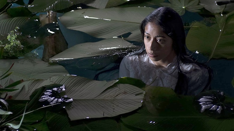 A young woman sits in the water