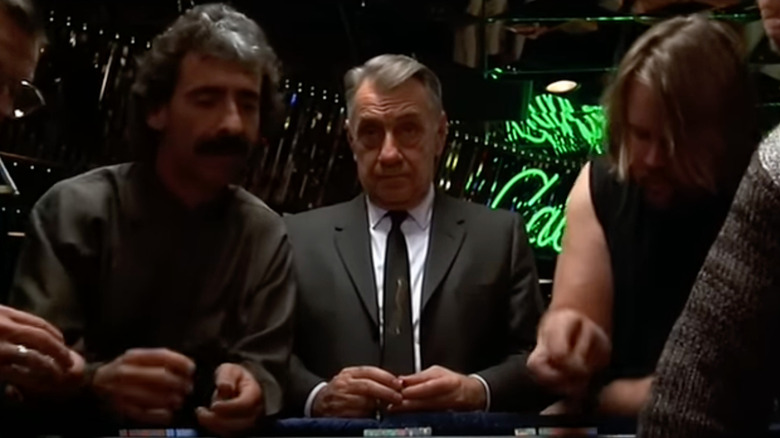 Philip Baker Hall as Sydney standing amongst gamblers in Hard Eight