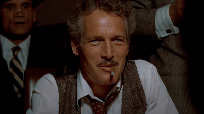 Paul Newman as Henry Gondorff smiles at a poker table in The Sting.