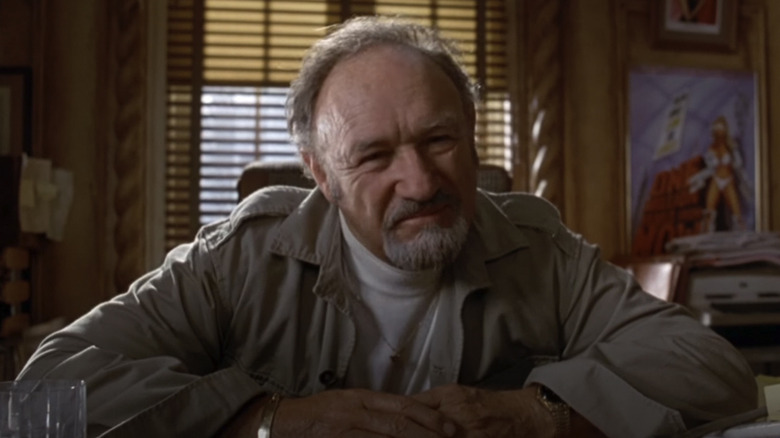 Gene Hackman sitting at desk