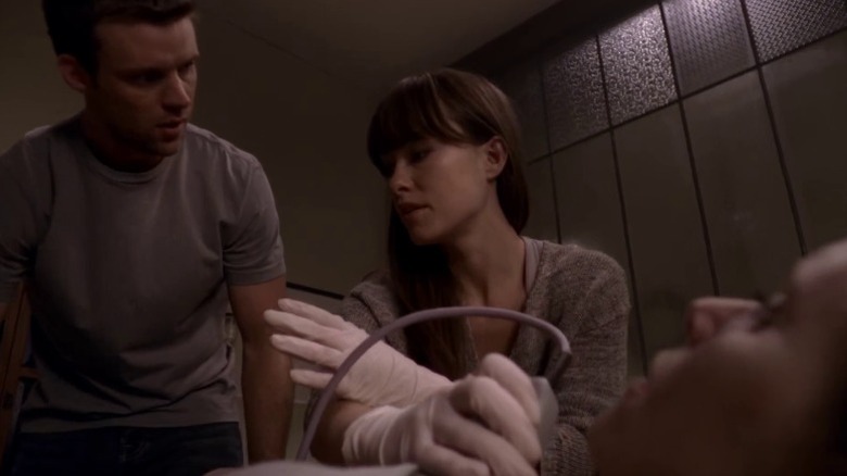 Jesse Spencer as Dr. Robert Chase and Olivia Wilde as Dr. Remy "Thirteen" Hadley help a patient on House