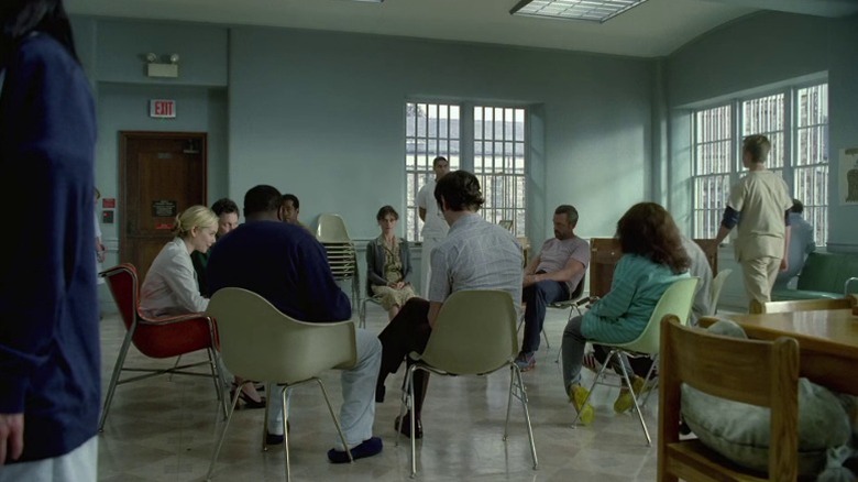 Dr. Beasley (Megan Dodds) and patients at Mayfield Psychiatric Hospital gathered around in a circle on House