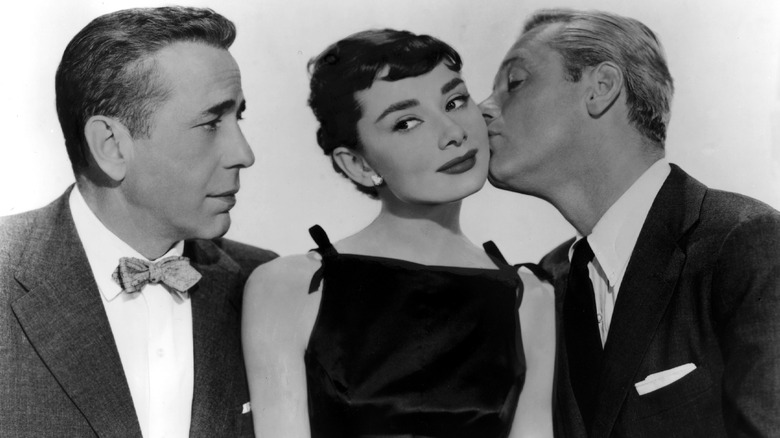 William Holden kisses Audrey Hepburn William Holden as Humphrey Bogart watches
