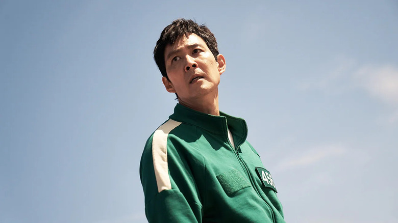 Gi-hun (Lee Jung-jae) stands in his green tracksuit in Squid Game