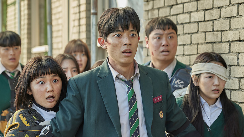 Lee Su-hyeok (Lomon) holds back his shocked classmates in All of Us Are Dead