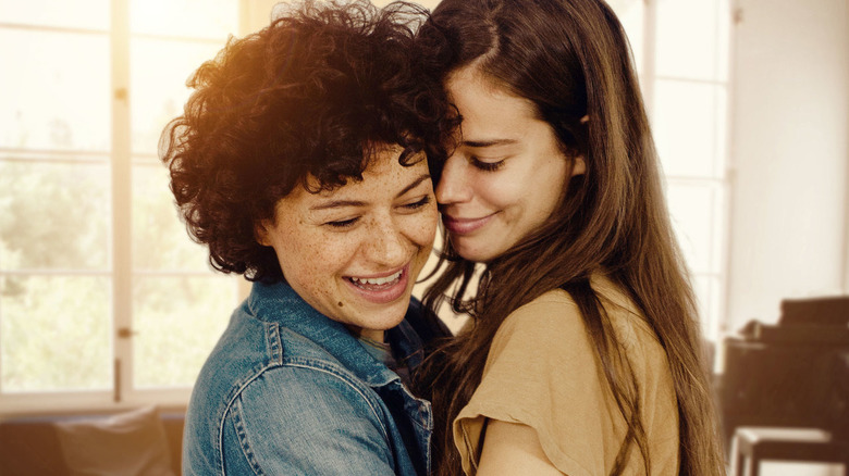 Two women stand close together