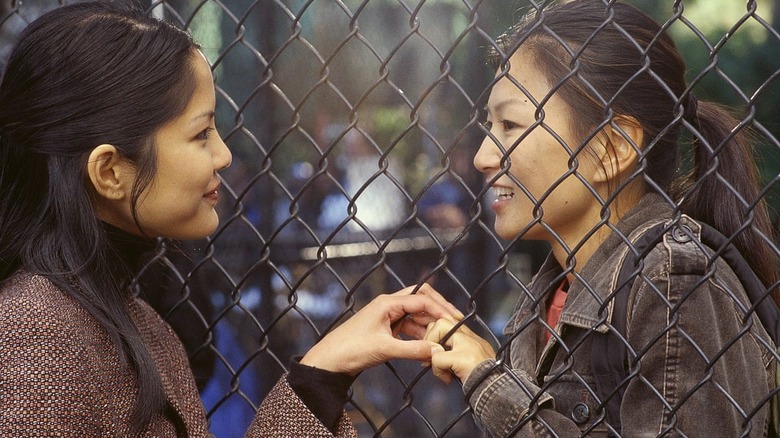 Two women hold hands 