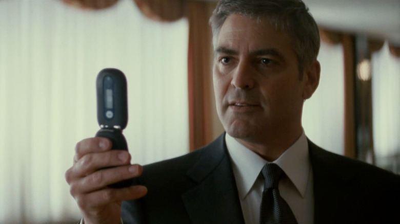 George Clooney as Michael Clayton, aiming a flip-phone camera in Michael Clayton