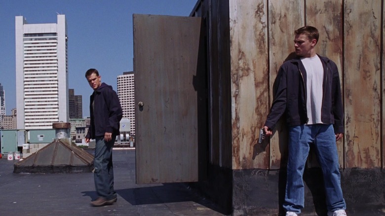 Matt Damon and Leonardo DiCaprio as Collin Sullivan and Billy Costigan Jr., meeting on a rooftop in The Departed