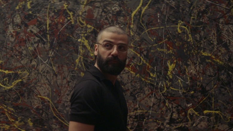 Nathan (Oscar Isaac) standing in front of abstract art in Ex Machina.