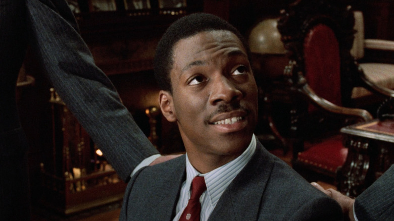 Eddie Murphy as Billy Ray Valentine sits in a chair in Trading Place