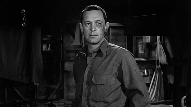 William Holden as Sefton looking bruised in Stalag 17