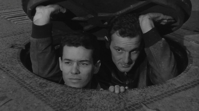 Two convicts exiting a manhole in Le Trou