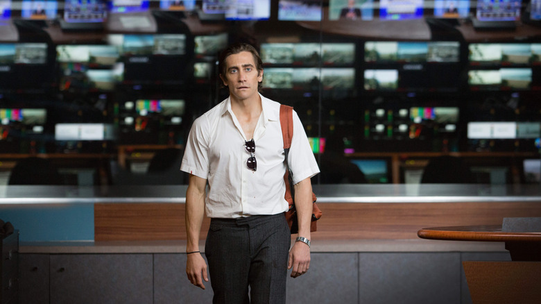 Lou Bloom (Jake Gyllenhaal) standing in front of TV monitors in Nightcrawler