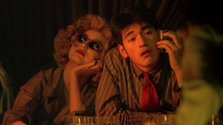 Brigitte Lin as the woman in the blond wig and Takeshi Kaneshiro as He Zhiwu drinking in Chungking Express