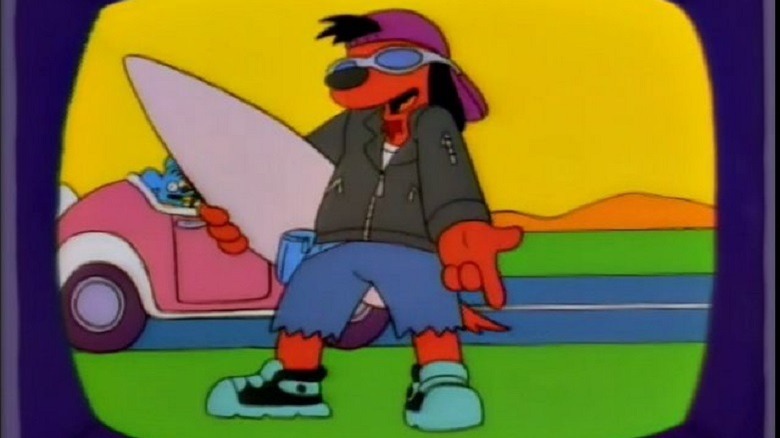 Poochie holding a surfboard