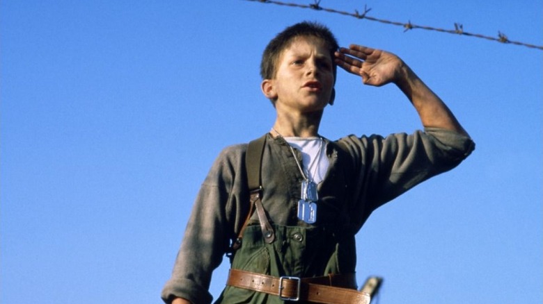 Jim salutes in front of barbed wire