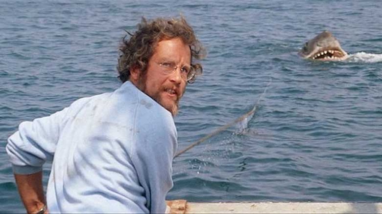 Hooper on boat facing away from emerging shark